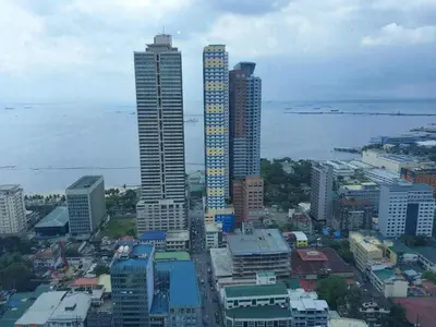 a city skyline with tall buildings and the ocean at 8 Adriatico Condotel Unit Facing Manila Bay in Manila