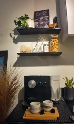 a kitchen with a counter with a coffee maker and dishes at NITO Modern Philippine Styled Home at Jazz Residences Makati in Manila