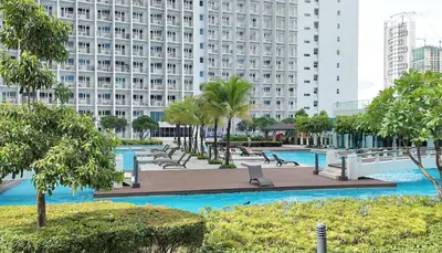 a resort with a pool and a large building at NITO Modern Philippine Styled Home at Jazz Residences Makati in Manila