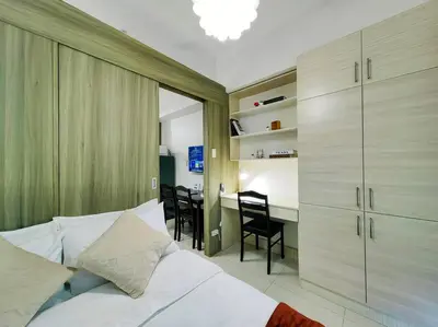 a bedroom with a bed and a desk with chairs at 1BR Condotel with Balcony at FAME Residences #FM07 in Manila