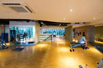 a gym with a man sitting on a chair in the middle at BGC Uptown Parksuites 2BR Skyline View with Balcony and Bathtub in Manila