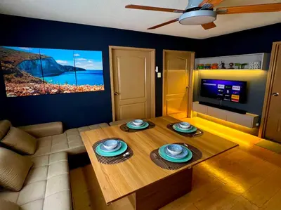 a living room with a wooden table and a tv at 2BR Italian-inspired Condo Unit, Balcony Pool View in Manila