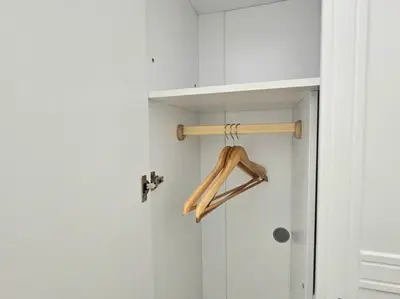 a closet with a wooden hanger on a door at The Infinity Towers in BGC - Spectacular 2BR near Hight Street in Manila