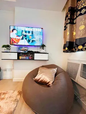 a large brown ottoman in a living room with a tv at Hope Stays in Manila