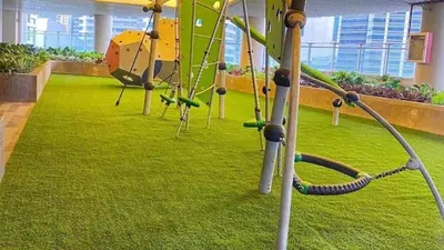 a playground in a building with green grass and swings at FCMCO Condotel in Manila