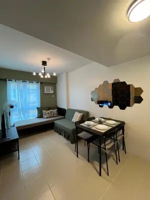 a living room with a couch and a table at The Rochester, Bridgeview Tower - 1BR Apartment in Manila