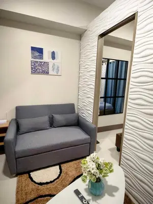 a living room with a couch and a mirror at Casa Fama - Fame Residences Staycation in Manila