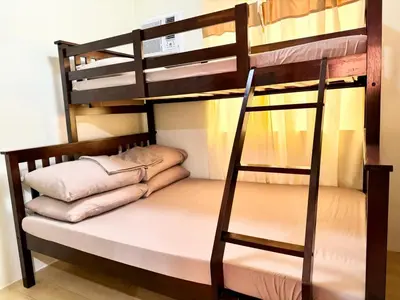 a bunk bed with a ladder and pillows on it at Your Comfort Zone Staycation1 in Manila