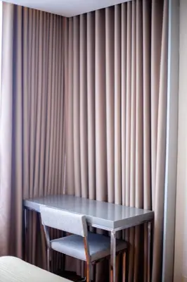 a table and a chair in front of a curtain at Antel Spa & Serenity Suites in Manila