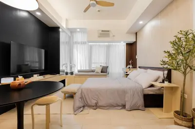 a bedroom with a bed and a living room at Eastwood City Cozy Designer Studio Long Stay Friendly Walk to Mall in Manila