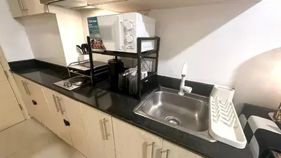 a kitchen counter with a sink and a microwave at South Pad Staycation Sea Residences SM Mall of Asia Tower A, B and E in Manila