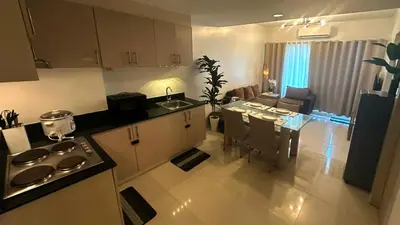 a kitchen and living room with a table and a dining room at South Pad Staycation Sea Residences SM Mall of Asia Tower A, B and E in Manila