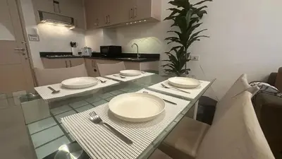 a table with plates and silverware on top of it at South Pad Staycation Sea Residences SM Mall of Asia Tower A, B and E in Manila