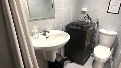a bathroom with a sink and a toilet at South Pad Staycation Sea Residences SM Mall of Asia Tower A, B and E in Manila