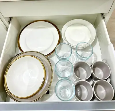 a bunch of plates and bowls in a drawer at Azure Luxury Suite in Manila