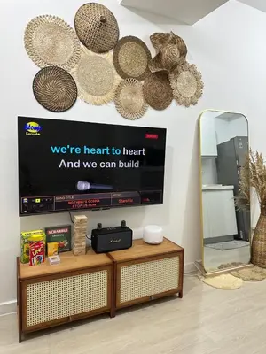 a living room with a tv and a mirror at Azure Luxury Suite in Manila