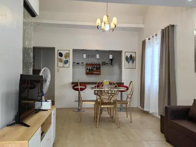 a dining room and living room with a table and chairs at Green Glory Staycation in Amadeo in Cavite
