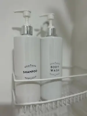 two bottles of shampoo and soap on a shelf at Jasrich Suite Behind SM trece martires HOPE RESIDENCES SMDC in Cavite
