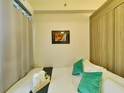 a small bedroom with a bed with two pillows at 1BR Condotel with Balcony FAME Residences #FM24 in Manila