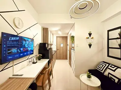 a living room with a large tv on a wall at 1BR Condotel with Balcony at FAME Residences #FM40 in Manila