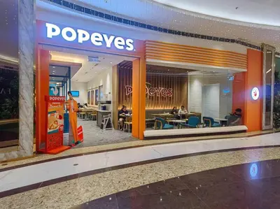 a pepsi store in a mall with people sitting in chairs at 1BR Condotel with Balcony at FAME Residences #FM41 in Manila