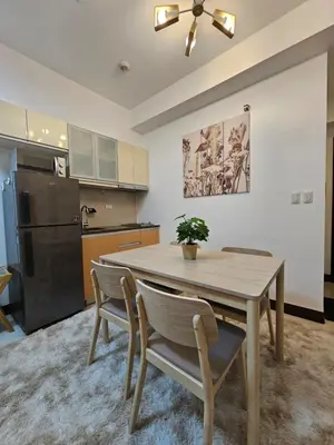 a kitchen with a dining room table and chairs at Affordable Condo Suite with 150mbps WIFI in Manila