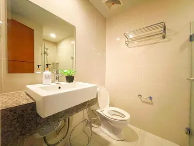 a bathroom with a sink and a toilet and a mirror at BGC Staycation: 1BR Condo Uptown Area #ournw12d in Manila