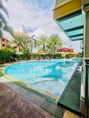 a large swimming pool in a resort with palm trees at Meteor Suites in Manila