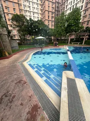 a large swimming pool in a city with tall buildings at Meteor Suites in Manila