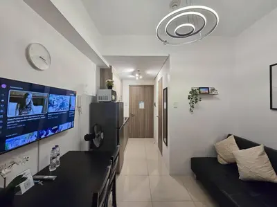 a living room with a couch and a flat screen tv at 1BR Condotel with Balcony at FAME Residences #FM43 in Manila