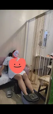 a woman is sitting on a bed with a heart at Condotel Near NAIA - massage chair footspa, dance revo, small pet allowed in Manila