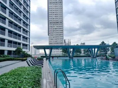 a swimming pool in a city with a tall building at 1BR Condotel with Balcony at FAME Residences #FM44 in Manila