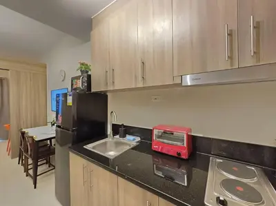 a kitchen with a counter top with a sink and a microwave at 1BR Condotel with Balcony at FAME Residences #FM44 in Manila