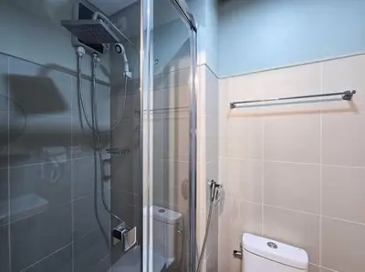 a bathroom with a shower with a toilet and a glass door at 1BR Condotel with Balcony at FAME Residences #FM45 in Manila