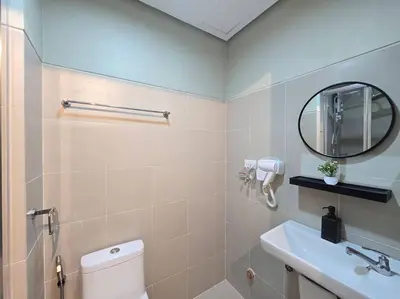 a bathroom with a toilet and a sink and a mirror at 1BR Condotel with Balcony at FAME Residences #FM48 in Manila