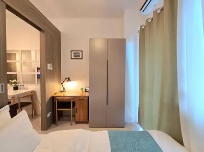 a bedroom with a bed and a desk in a room at 1BR Condotel with Balcony at FAME Residences #FM49 in Manila