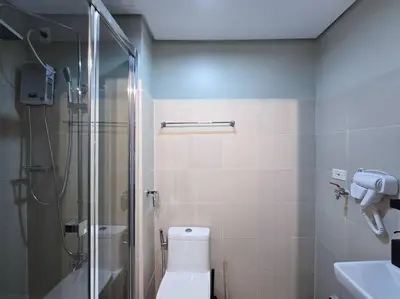 a bathroom with a shower and a toilet and a sink at 1BR Condotel with Balcony at FAME Residences #FM49 in Manila