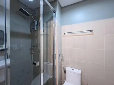 a bathroom with a toilet and a glass shower at 1BR Condotel with Balcony at FAME Residences #FM49 in Manila