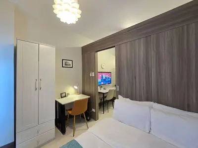 a bedroom with a bed and a desk and a table at 1BR Condotel with Balcony at FAME Residences #FM50 in Manila