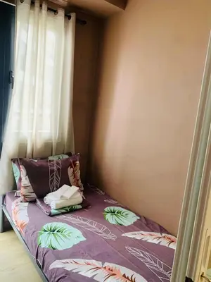 a small bed in a room with a window at SPRING RESIDENCES - 2BR Condo near Airport with balcony and pool views in Manila