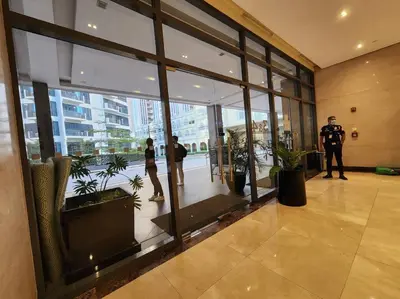 a police officer standing in a lobby with people in a building at Studio at viceroy 4 Taguig in Manila