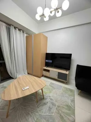 a living room with a coffee table and a flat screen tv at Studio at viceroy 4 Taguig in Manila