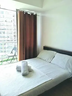 a bedroom with a bed with two towels on it at Azure - Stellar Property in Manila