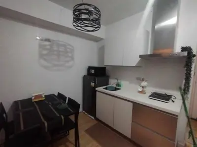 a kitchen with a counter and a refrigerator in a room at Azure - Stellar Property in Manila