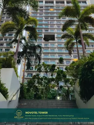 a large building with palm trees in front of it at Novotel Twin Bed at Mandaluyong Near Makati FREE pool in Manila