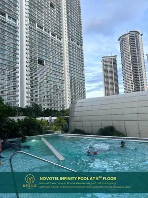a swimming pool in the middle of some tall buildings at Novotel Twin Bed at Mandaluyong Near Makati FREE pool in Manila