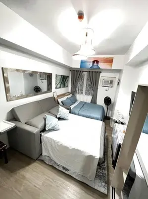 a living room with a bed and a couch at University Belt Cozy Studio at Vista Recto-33rd Floor in Manila