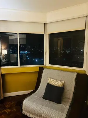 a couch in front of a window with a view of a city at Greenhills 1BR Lower Penthouse w Panoramic View in Manila