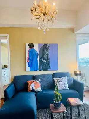 a blue couch in a living room with a chandelier at Greenhills 1BR Lower Penthouse w Panoramic View in Manila