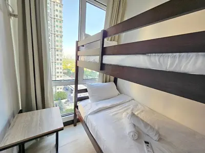 a bedroom with a bunk bed and a large window at Spacious 2BR Condo San Lorenzo Place 4KM Airport in Manila